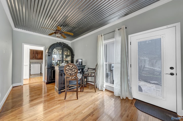 dining space featuring ceiling fan, a healthy amount of sunlight, ornamental molding, and hardwood / wood-style floors