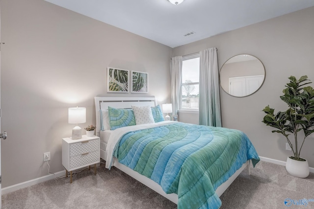 bedroom with carpet floors, visible vents, and baseboards