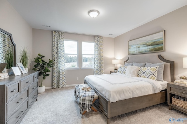 bedroom featuring baseboards, visible vents, and light colored carpet