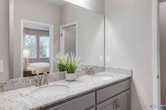 ensuite bathroom featuring a sink, ensuite bath, and double vanity