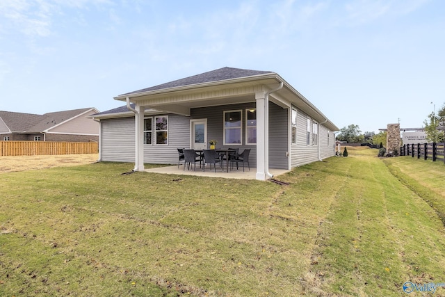 rear view of house featuring a patio area, fence, and a lawn