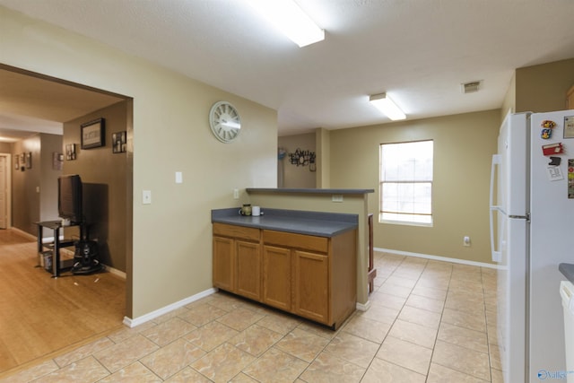 kitchen with white refrigerator and light tile patterned flooring