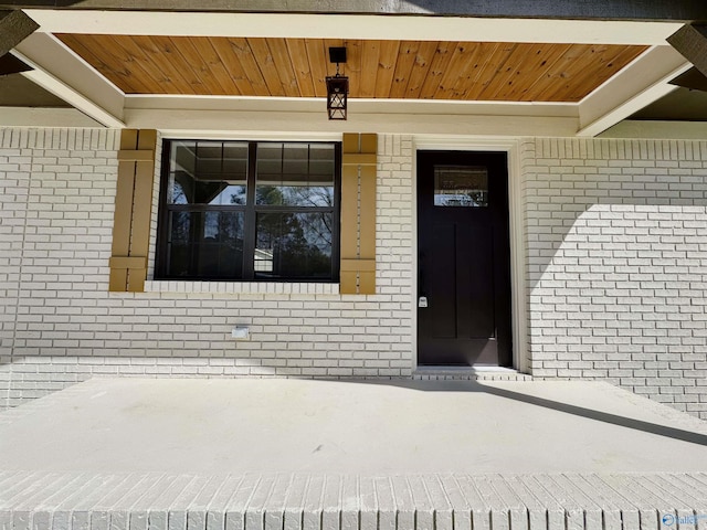 doorway to property featuring brick siding