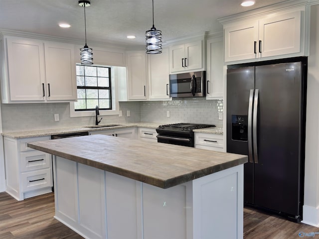 kitchen featuring black range with gas stovetop, a sink, wooden counters, stainless steel microwave, and fridge with ice dispenser