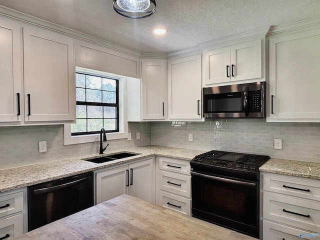 kitchen featuring backsplash, a sink, white cabinetry, and black appliances