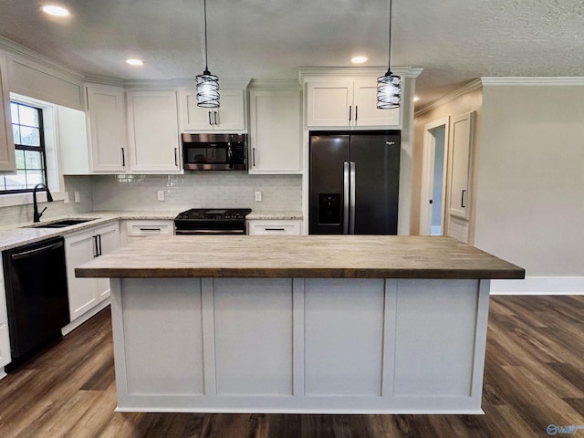 kitchen with white cabinetry, tasteful backsplash, a center island, a sink, and black appliances