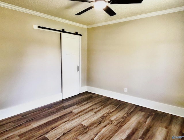unfurnished bedroom with dark wood-style flooring, crown molding, a barn door, and a textured ceiling