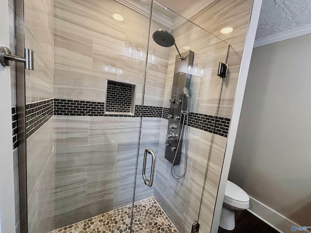 full bath with toilet, crown molding, and a shower stall
