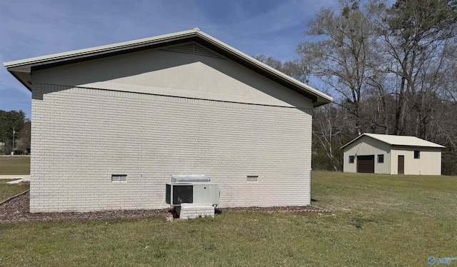 view of side of property featuring an outbuilding and a lawn