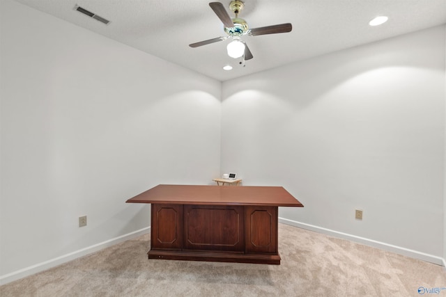 unfurnished office with ceiling fan and light colored carpet