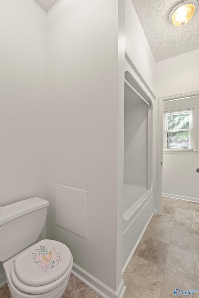 bathroom with a textured ceiling and toilet