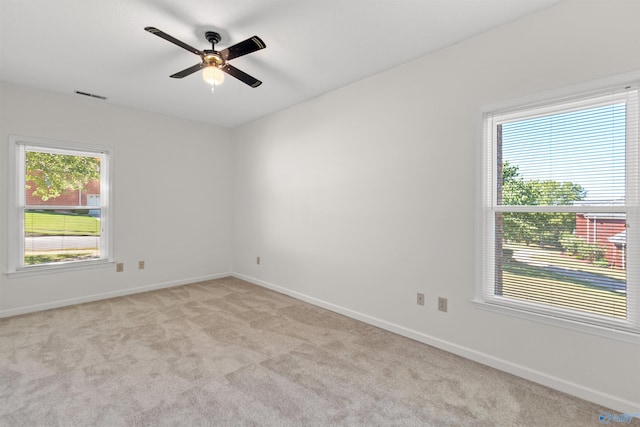 spare room with ceiling fan and light carpet