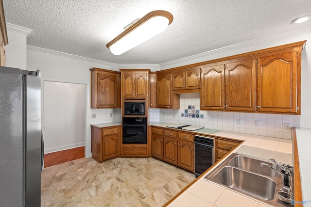 kitchen with a textured ceiling, sink, black appliances, backsplash, and ornamental molding