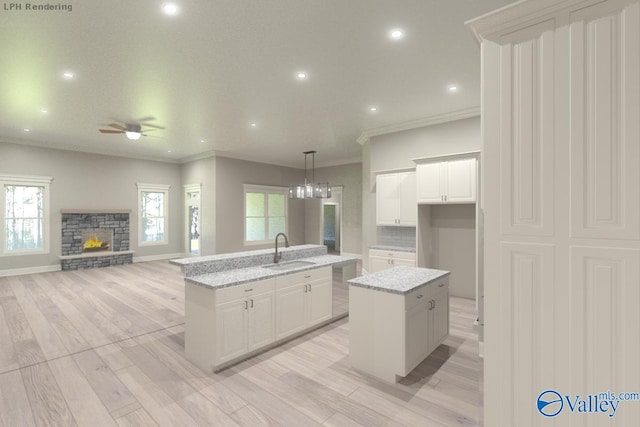 CAMBRIDGEE2 Mallard Dr, Madison, AL 35756 - kitchen with an island with sink, a sink, a ceiling fan, crown molding, and a stone fireplace