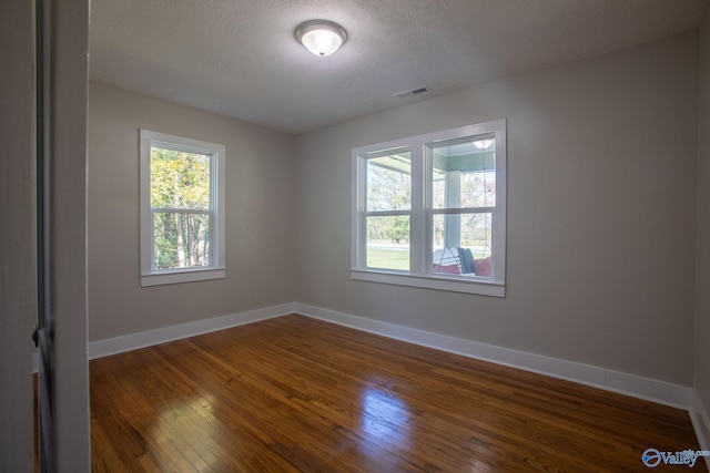 unfurnished room featuring dark hardwood / wood-style floors and a textured ceiling