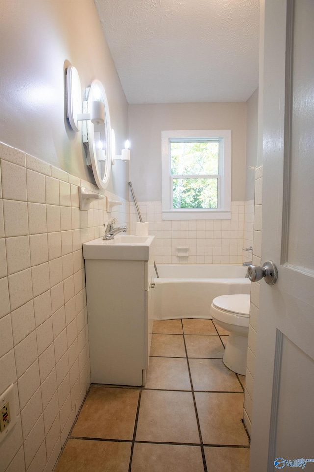 bathroom featuring tile patterned flooring, vanity, toilet, and tile walls