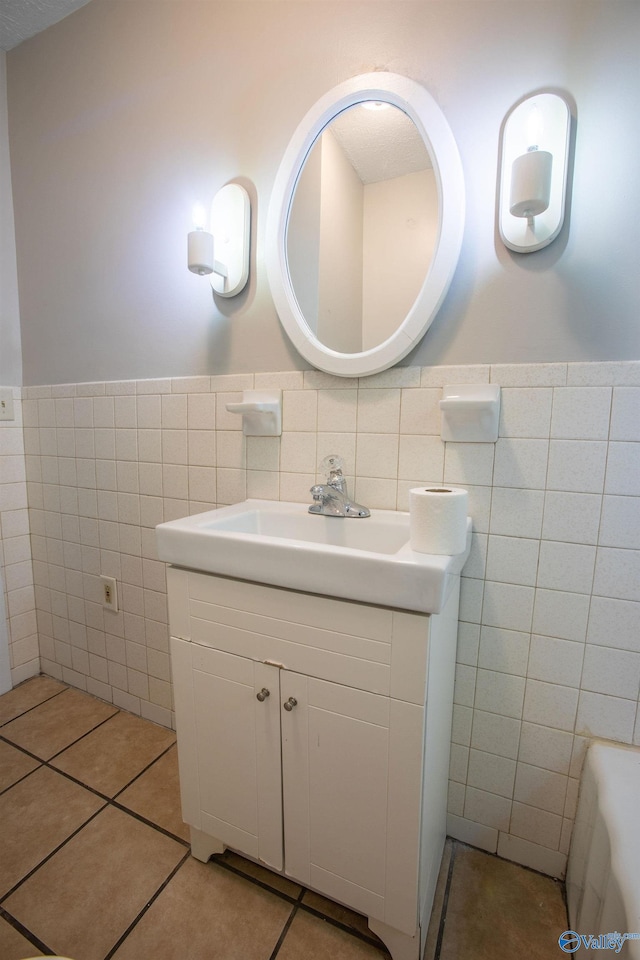 bathroom featuring tile patterned flooring, vanity, and tile walls