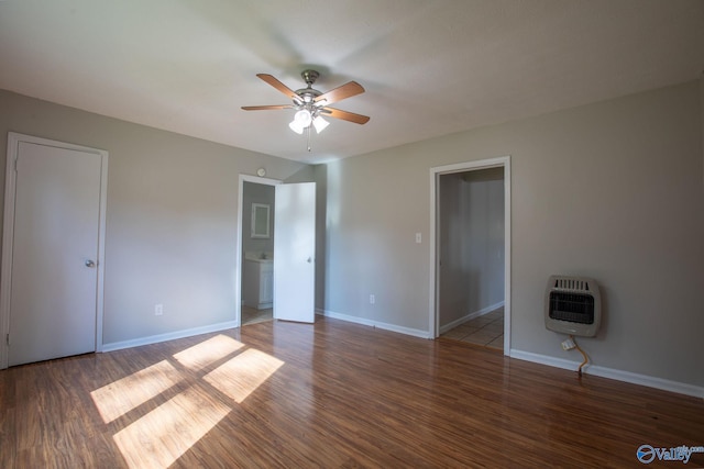 interior space with heating unit, ceiling fan, and dark wood-type flooring