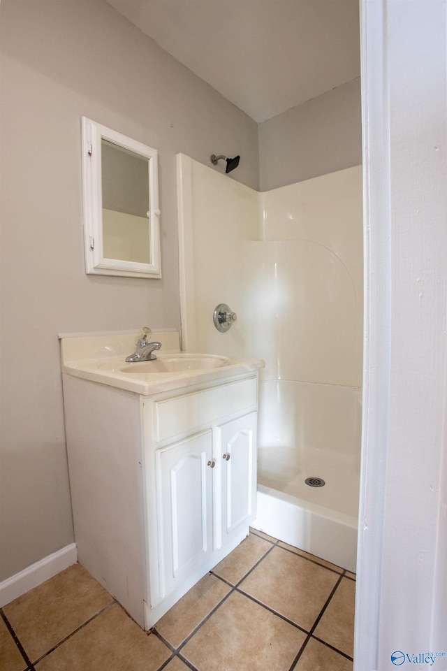 bathroom with tile patterned floors, a shower, and vanity