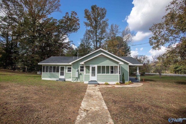 view of front facade featuring a front lawn and a sunroom