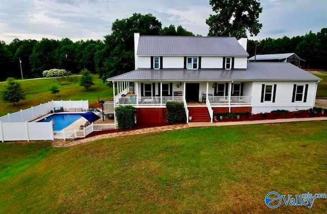 view of front of house with a front yard, a porch, and a fenced in pool