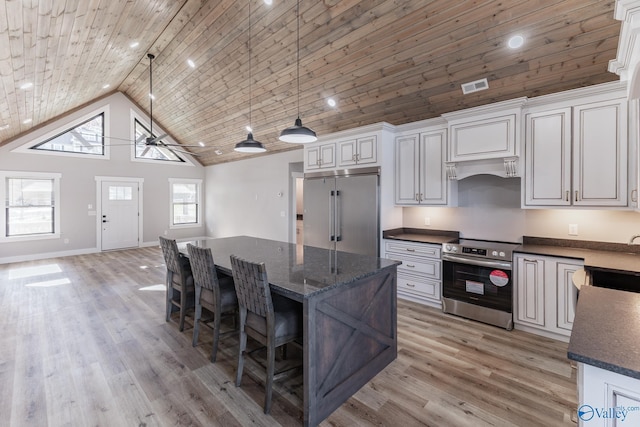 kitchen with white cabinets, high vaulted ceiling, and appliances with stainless steel finishes