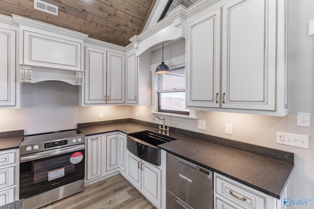 kitchen with sink, white cabinets, vaulted ceiling, and appliances with stainless steel finishes