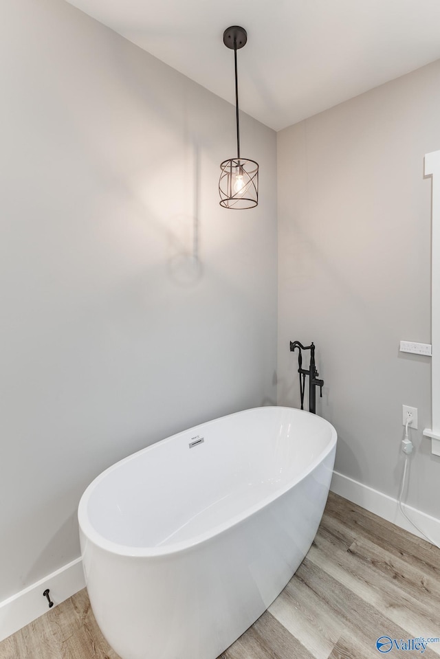 bathroom with hardwood / wood-style floors and a bath