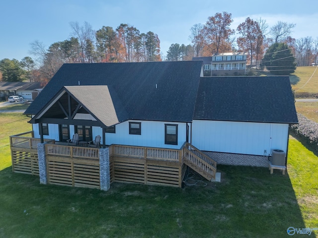 back of property with a deck, central AC unit, and a lawn