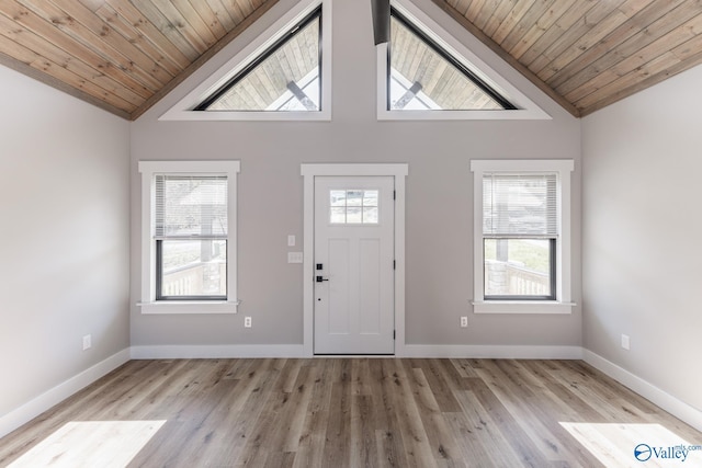 entryway with light hardwood / wood-style floors, high vaulted ceiling, a wealth of natural light, and wooden ceiling