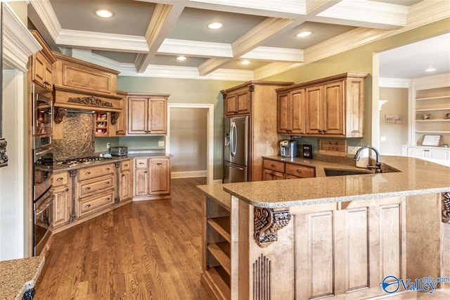 kitchen with kitchen peninsula, appliances with stainless steel finishes, coffered ceiling, sink, and beam ceiling