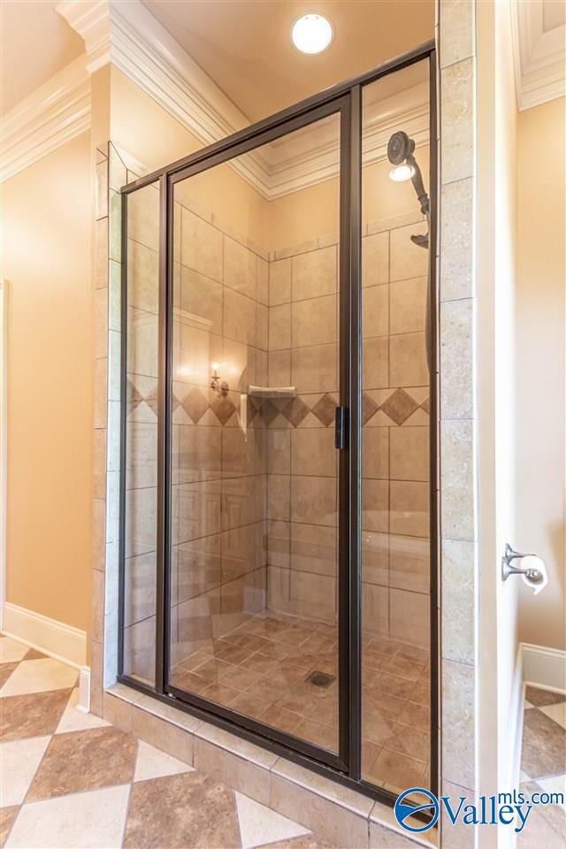 bathroom with a stall shower, baseboards, and crown molding