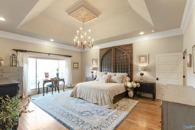 bedroom with light wood finished floors, a tray ceiling, recessed lighting, and crown molding