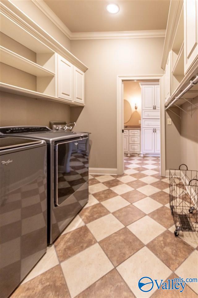 laundry area with cabinets, separate washer and dryer, and ornamental molding