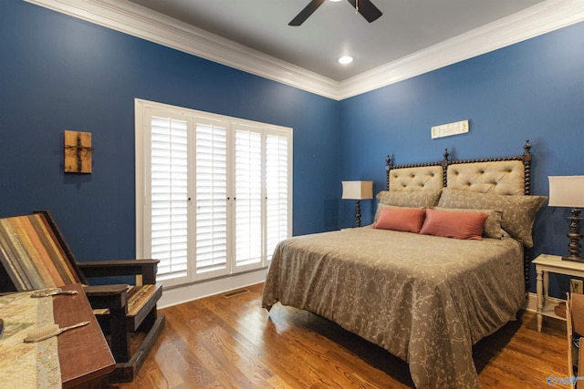 bedroom with a ceiling fan, visible vents, ornamental molding, and wood finished floors