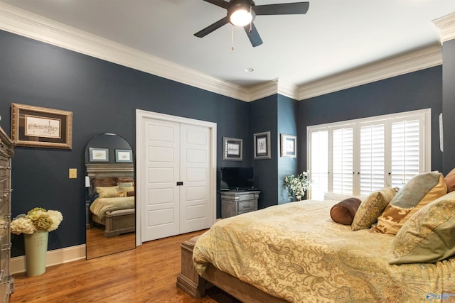 bedroom featuring wood-type flooring, a closet, ceiling fan, and crown molding