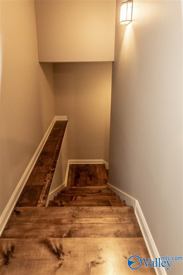 staircase featuring baseboards and wood finished floors