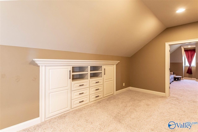 additional living space with light carpet, baseboards, and vaulted ceiling