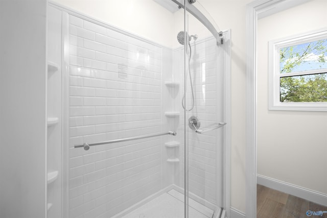 bathroom with a shower stall, baseboards, and wood finished floors