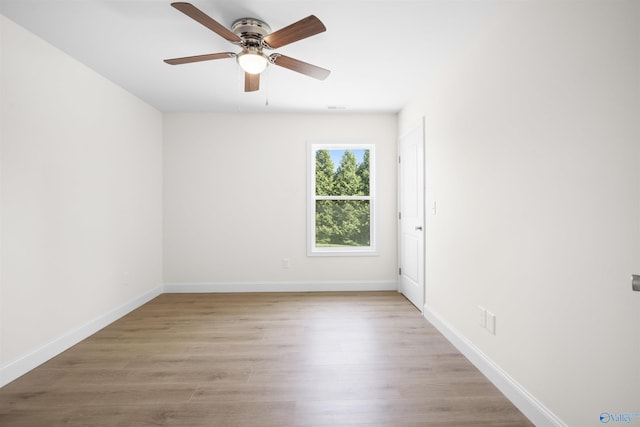 unfurnished room with wood finished floors, baseboards, and a ceiling fan