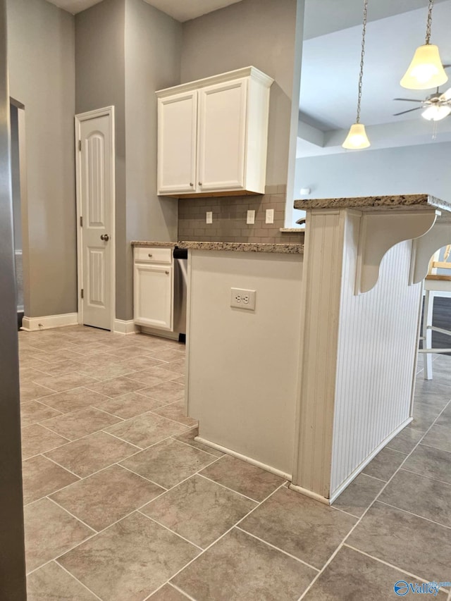 kitchen featuring tasteful backsplash, a breakfast bar, tile patterned flooring, white cabinetry, and hanging light fixtures