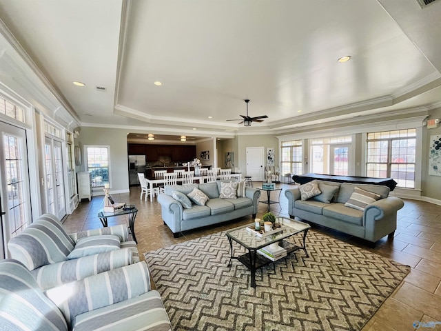 tiled living room with plenty of natural light, crown molding, and a tray ceiling