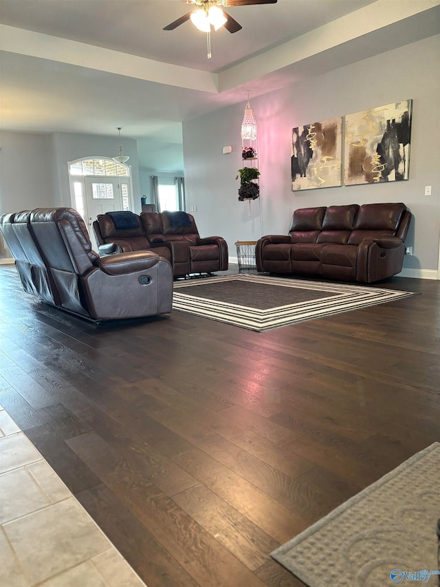 living room with ceiling fan and dark wood-type flooring