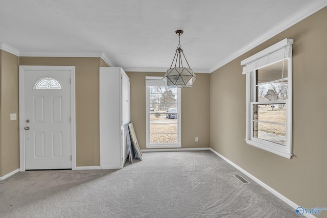 carpeted entryway featuring visible vents, baseboards, and crown molding