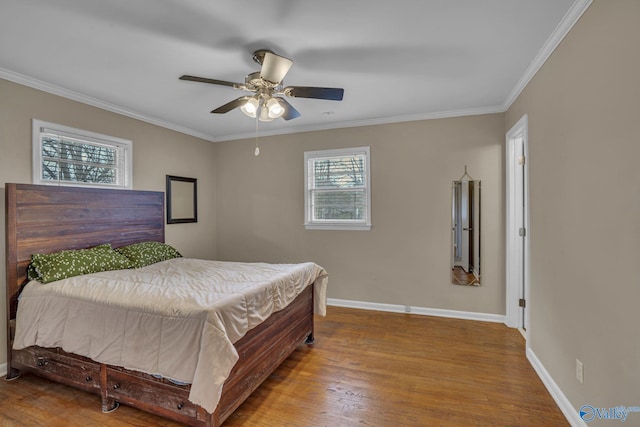 bedroom featuring a ceiling fan, baseboards, wood finished floors, and ornamental molding