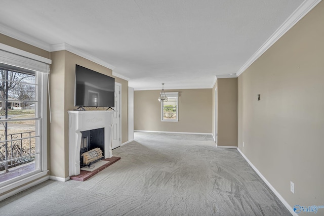 unfurnished living room featuring carpet, baseboards, a fireplace with raised hearth, and crown molding