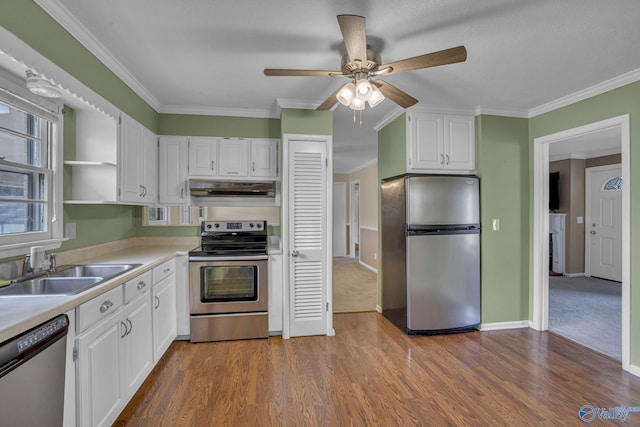 kitchen featuring light countertops, appliances with stainless steel finishes, white cabinets, a sink, and under cabinet range hood