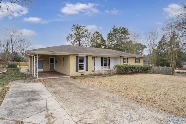 single story home with concrete driveway, brick siding, roof with shingles, and fence