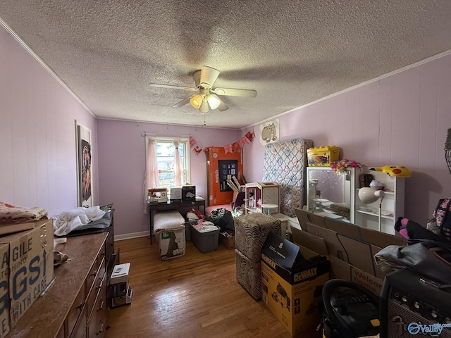 bedroom featuring ceiling fan, a textured ceiling, wood finished floors, and crown molding