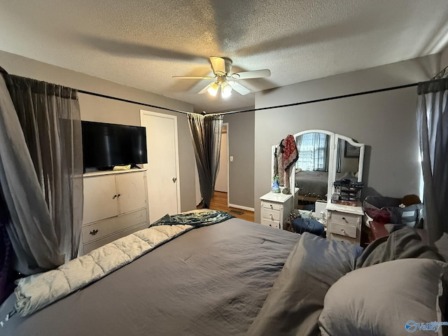 bedroom with ceiling fan and a textured ceiling